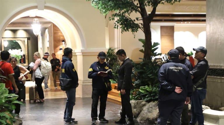 Police officers talk to ​a ‍staff member at⁤ the Grand Hyatt Erawan Hotel in Bangkok, Thailand.